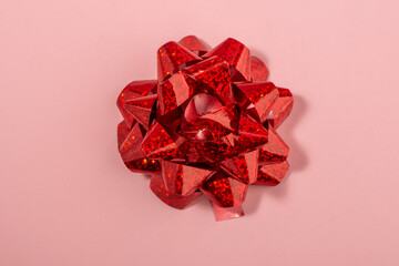 Large red bow on pink background, top view