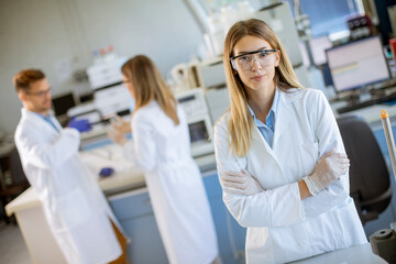 Female scientist in white lab coat standing in the biomedical lab