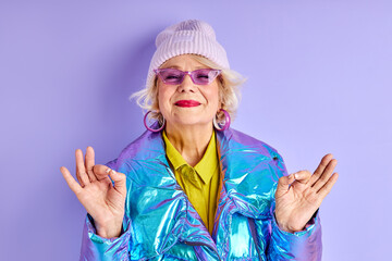 meditating lady in fancy clothes, optimistic caucasian mature woman keen on yoga, look at camera...