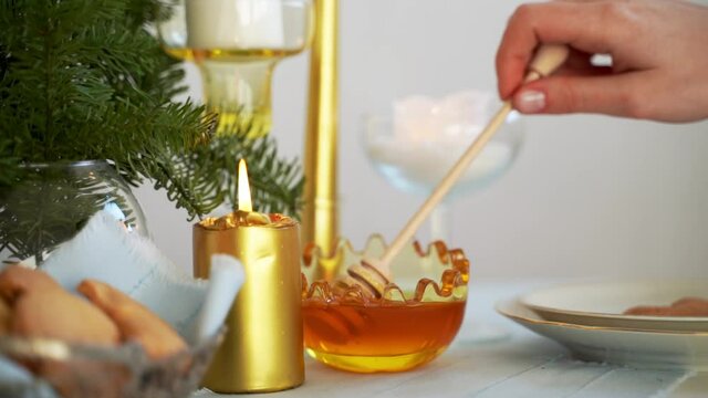 WOman pouring honey in glass bowl. Raw healthy food
