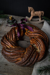 Couronne - French Christmas cake with cinnamon and brown sugar decorated with purple ribbon on linen fabric on wooden table.
