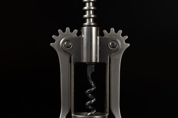 Metal corkscrew close-up and macro on the black background.
