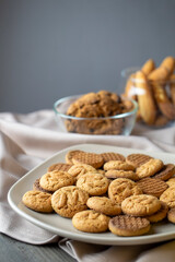 On wooden table against gray wall on plate pile of cookies close-up.