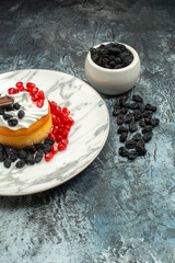 front view yummy creamy cake with chocolate pomegranates and raisins on light-dark background cookie sugar biscuits sweet pie