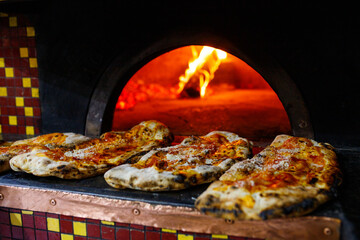 Ripieni al forno con mozzarella e prosciutto e ricotta appena cotti e appoggiati sul forno a legna 