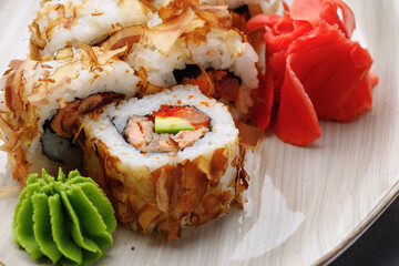 Sushi roll with tuna shavings on plate close up