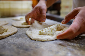 Pizzaiolo mentre chiude una pizza fritta ripiena di ricotta e pepe