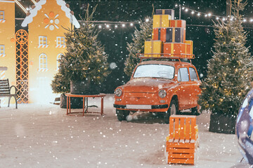 New Year's and Christmas location on the open air. Red retro car. Snowfall, lights. Christmas mood.