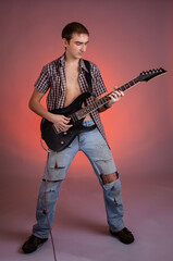 Fototapeta na wymiar Young guitarist play music on his electric guitar with bright emotions. 