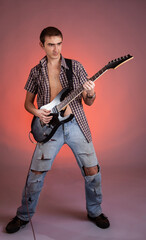 Fototapeta premium Young guitarist play music on his electric guitar with bright emotions. 