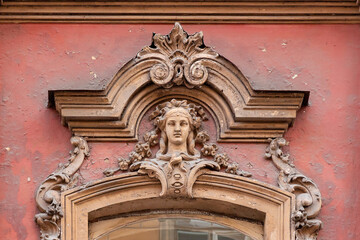 Mascaron in the form of a female head above the window