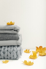 Stack of gray warm plaids decorated maple leaves