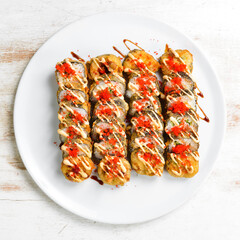 Traditional Japanese sushi rolls on a white plate. Top view. Asian food. On a white background.