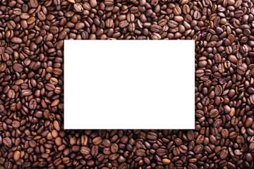 Roasted beans background with coffee grains, white epmty board