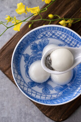Top view of tangyuan in a bowl on gray background for lunar new year food.