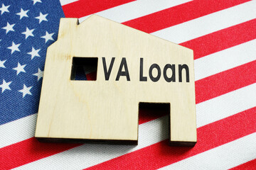Fototapeta na wymiar VA loan sign on the wooden home and American flag.