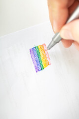 A male hand is drawing an LGBT symbol of homosexuality