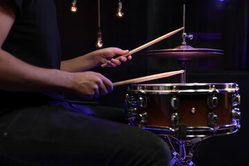Drummer playing snare drum with sticks close up.