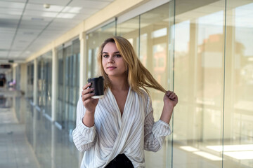 beautiful young woman enjoys coffee and listens to music during lunch break