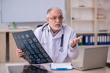 Old male doctor radiologist working in the clinic