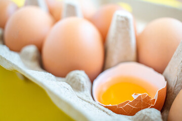 Closeup cracked brown eggs Arranged in a paper box Buy from supermarket Placed on a yellow background