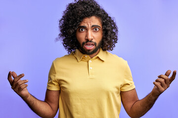 man spreading hands, uncomfortable situation, curly arabic male is misunderstanding, isolated