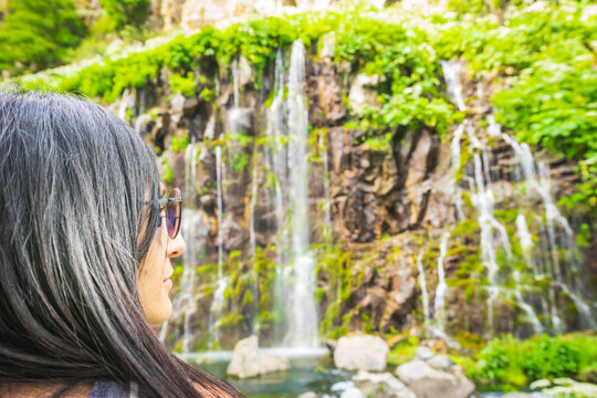 Portrait of caucasian woman look to camera with dramatic Dashbashi canyon watefall in background