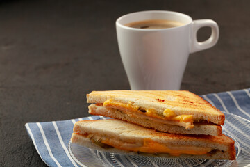 Toast sandwich and cup of coffee on napkin on wooden table