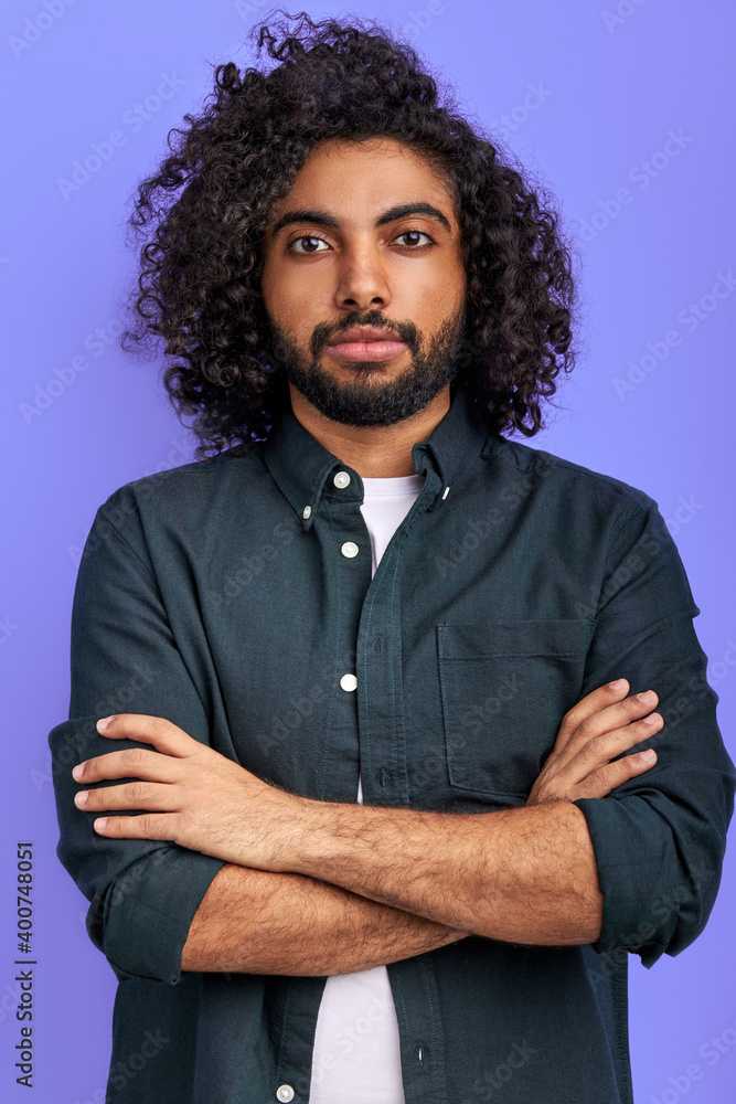 Wall mural arabic guy posing confidently looking at camera, young bearded male with dark skin in studio, stand 