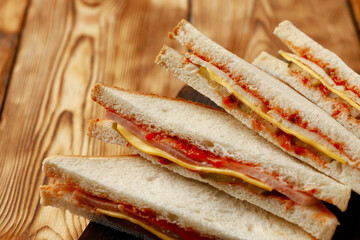 Sandwiches cut into halves on wooden cutting board with napkin