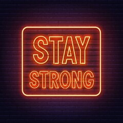 Stay strong neon quote on a brick wall. Inspirational glowing lettering.