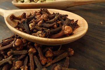 Heap of clove spice on wooden table