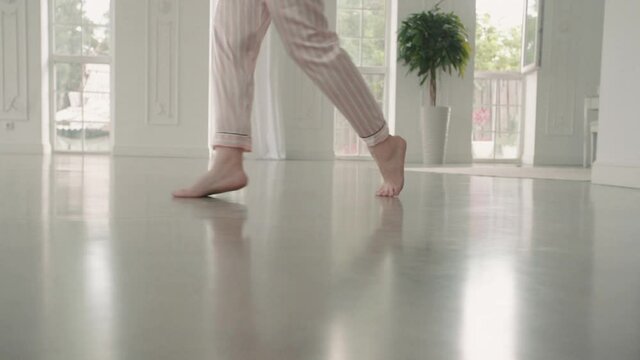 Feet of graceful woman walk on tiptoe at home or hotel before wedding. Young female run in pajamas