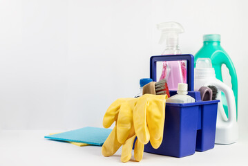 Cleaning gloves and various bottles with detergent on a white background