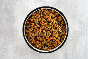Pet food in a bowl on a gray background. View from above