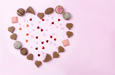 Chocolate candies heart on pink background. Valentines  and mother day postcard  with copy space .