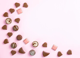 Fototapeta na wymiar Chocolate candies assortment on pink background with copy space .. Valentines and mother day postcard .