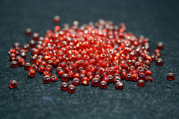 Red beads on a black felt background.