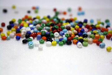 Colorful beads on a white felt background.