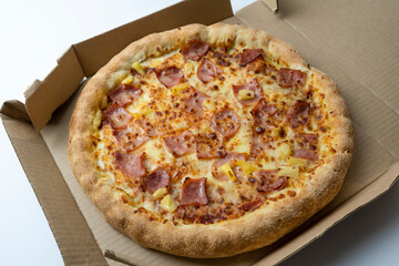Hawaiian Pizza with bacon , cheese and pineapple on cardboard box .Restaurant promotion concept on white background.