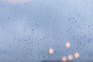 A window covered with raindrops, a wet window during a heavy downpour. Glass surface texture, large...