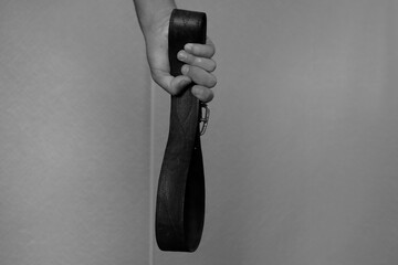 a belt in the hand of a father who wants to hit his child. domestic violence with copy space