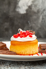 front close view berry cake and chocolates on white oval plate on grey-white isolated background with free space