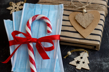 Holidays, winter and celebration concept with gifts, medical mask and decor