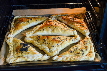 Home baked pies. Pies on a baking sheet in the oven.