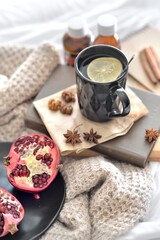 Fototapeta na wymiar Natural flu home remedies: hot tea cups with lemon and walnut and pomegranate to boost immune system. Natural healthy food and hot drink ingredients for immunity stimulation and against viruses.