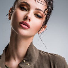 Closeup portrait of a beautiful young fashion woman with glamour makeup posing at studio.