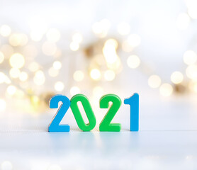 Figures 2021 on a background of garlands and bokeh. Blue, green, gold, white,  yellow background....