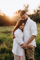 young couple in love a guy with a beard and a girl with dark hair in light clothes