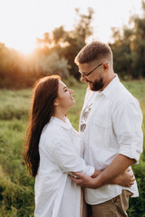 young couple in love a guy with a beard and a girl with dark hair in light clothes